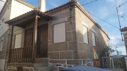a brick house with a porch and a door at Casa do Soalheiro in Castanheiro