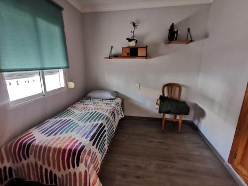 オリーバにあるCaseta en la playa de Olivaのベッドと椅子のある小さな寝室