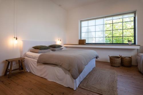 a bedroom with two beds and a large window at Ateliér v raji in Spišské Tomášovce