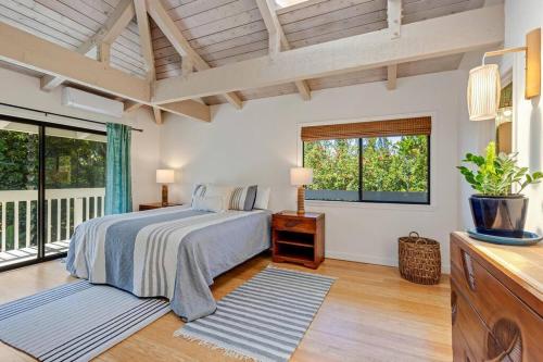 1 dormitorio con cama y ventana grande en Newly listed luxury home - great location + views, en Princeville