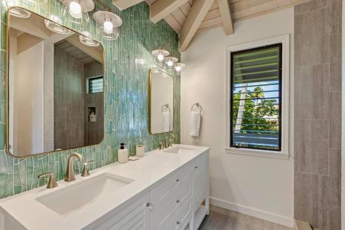 W łazience znajduje się umywalka i lustro. w obiekcie Newly listed luxury home - great location + views w mieście Princeville