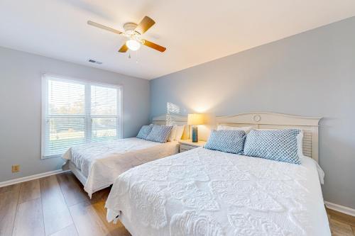 une chambre avec deux lits et un ventilateur de plafond dans l'établissement Ev's Escape, à Sunset Beach