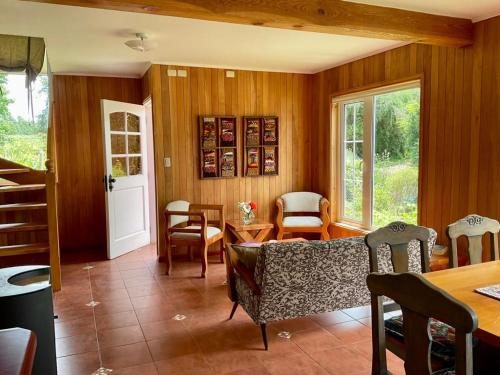 a living room with a couch and a table and chairs at Casa Viña in Valdivia