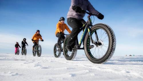a group of people riding bikes in the snow at Nallikari Seaside Aalto Apartments in Oulu