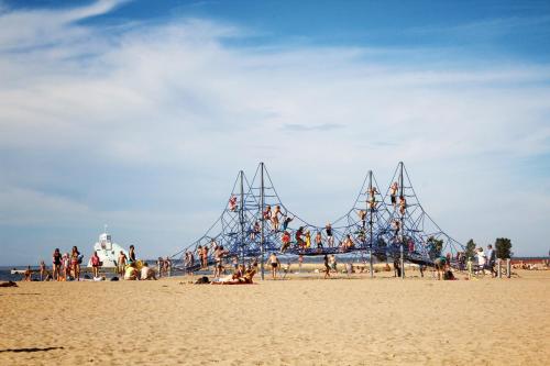 a roller coaster on a beach with people on it at Nallikari Seaside Aalto Apartments in Oulu