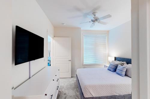 a white bedroom with a bed and a flat screen tv at Piers At Pike in Seattle