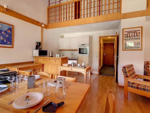 une cuisine et une salle à manger avec une table en bois dans l'établissement Duplex spacieux aux pieds des pistes avec parking et balcon - FR-1-344-732, à Saint-Martin-de-Belleville