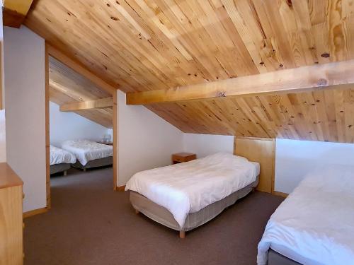 a bedroom with two beds and a wooden ceiling at Duplex spacieux aux pieds des pistes avec parking et balcon - FR-1-344-732 in Saint-Martin-de-Belleville