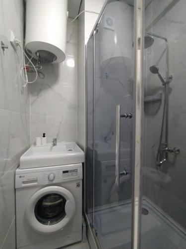 a bathroom with a washing machine and a shower at AURA on Jumabek street 233 in Bishkek