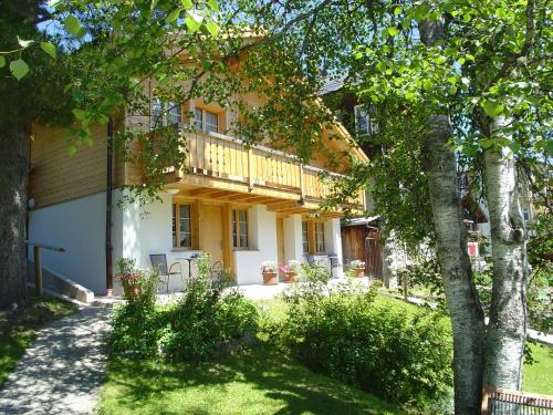 a house with a balcony and a yard at Hotel Blumental in Mürren
