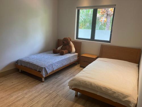 un osito de peluche sentado en una cama en un dormitorio en Luxury villa en Tamarin