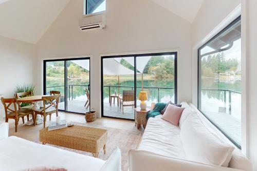 ein Wohnzimmer mit einem weißen Sofa und großen Fenstern in der Unterkunft Cedrona Cove Cottage in Fox Island