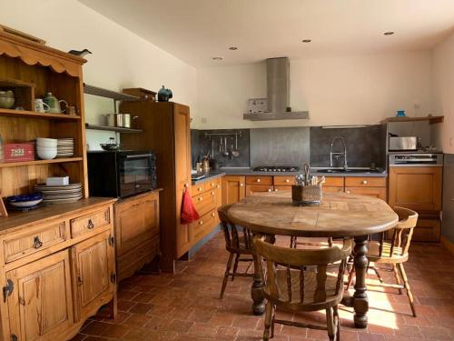 una cocina con mesa y sillas. en Lumière et verdure, maison de campagne, en Miniac-Morvan