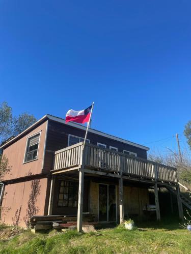 una bandera ondeando frente a una casa en Cabaña cerca del Aeropuerto, en Puerto Montt