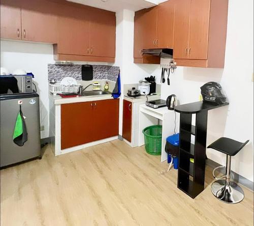 a small kitchen with brown cabinets and a sink at One Bedroom Condo with fast wifi at Eastwood Lafayette tower Quezon city in Manila