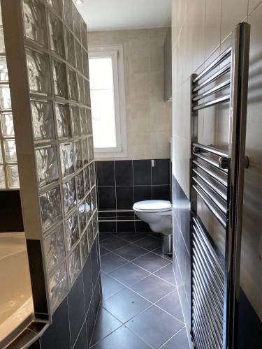 une salle de bain avec toilettes et fenêtre dans l'établissement Bel appartement proche de Paris, à Colombes