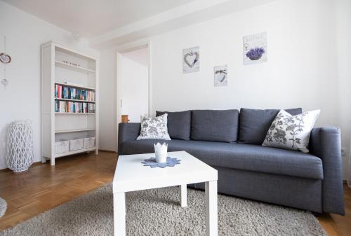 ein Wohnzimmer mit einem blauen Sofa und einem weißen Couchtisch in der Unterkunft Ferienwohnung Lavendel 