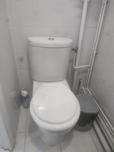 a bathroom with a white toilet and a trash can at Oasis de détente in Aubervilliers