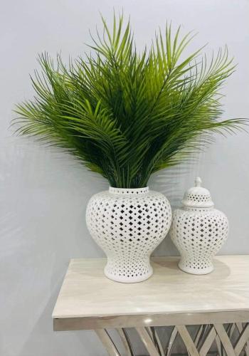 two white vases sitting on a table with a plant at Revive Haven Valley in Roodepoort