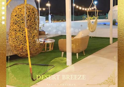 a poster of a resort with a chair and a hammock at Desert Breeze Resort in Ras al Khaimah