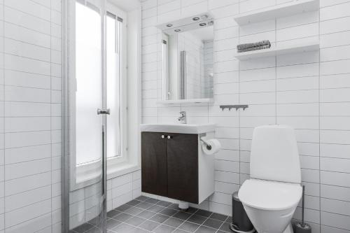 a white bathroom with a toilet and a sink at Funäs Ski Lodge in Funäsdalen