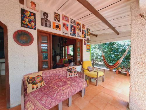 een woonkamer met een bank en wat foto's aan de muur bij Macondo Hostel in Isla Grande