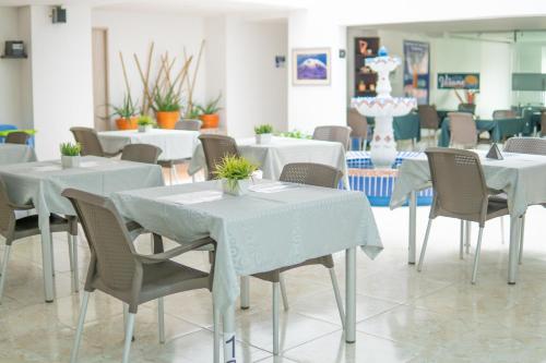 a dining room with white tables and chairs at HOTEL VERANO in Ibagué