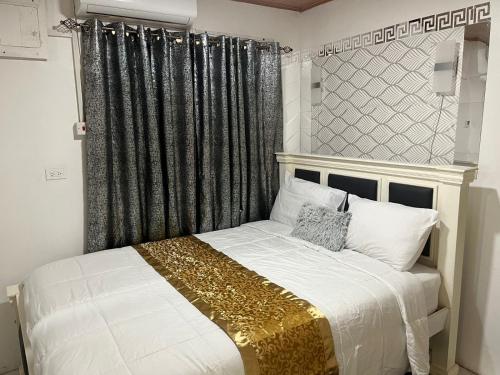 a bedroom with a bed with a black and gold headboard at Odyssey Suites Loft Apartment in Georgetown