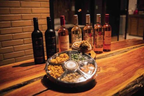 una bandeja de comida en una mesa con botellas de vino en Casa ecológica Toca do Barreiro, en Coronel José Diaz