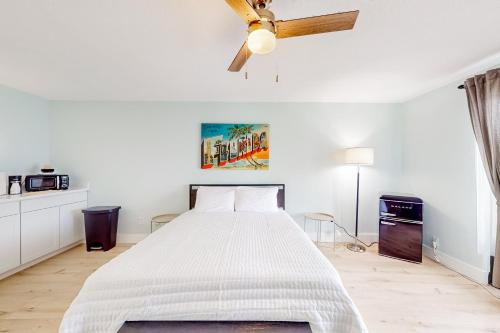 a white bedroom with a bed and a ceiling fan at Capri 103 in Marco Island