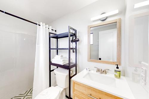 ein Badezimmer mit einem Waschbecken, einem WC und einem Spiegel in der Unterkunft Capri 103 in Marco Island