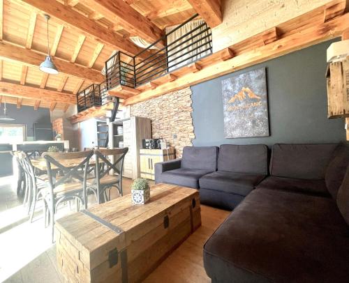 a living room with a couch and a table at Chalet le petit Nicolas, jacuzzi, vue Mont Blanc in Chamonix-Mont-Blanc