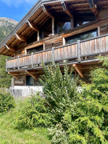 a wooden house with a balcony on the side of it at Chalet le petit Nicolas, jacuzzi, vue Mont Blanc in Chamonix-Mont-Blanc