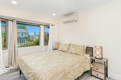 a white bedroom with a bed and a window at Woodland Park Villa in Seattle