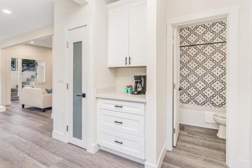 een keuken met witte kasten en een deur naar een woonkamer bij Woodland Park Villa in Seattle