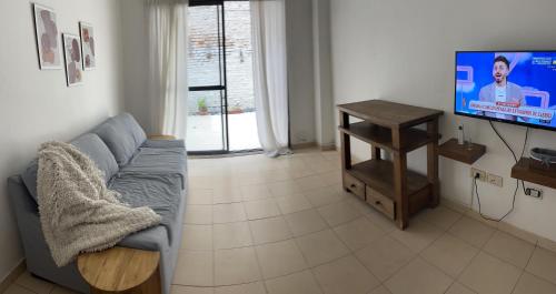 ein Wohnzimmer mit Sofa und Flachbildfernseher in der Unterkunft Baires Garden in Buenos Aires