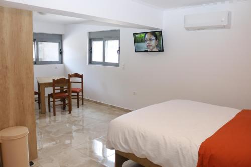 1 dormitorio con 1 cama, mesa y sillas en ALTAVILLAS Apartment 3 DANIEL, en Kakí Vígla