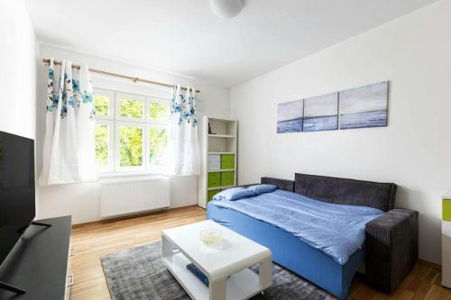una camera con un letto blu e un tavolo di Modern Apartment 6min from the Prague Castle a Praga
