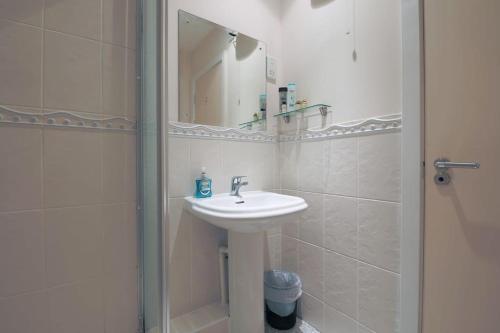 a white bathroom with a sink and a mirror at 2 bed spacious apartment in Cardiff CC in Cardiff
