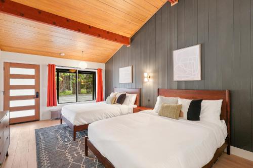 une chambre avec deux lits et un plafond en bois dans l'établissement Cave Springs Resort, à Dunsmuir
