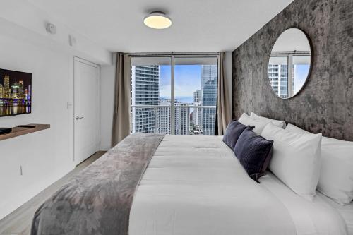 una camera da letto con un grande letto e un grande specchio di LUX 2B/2B Brickell - Free Parking a Miami