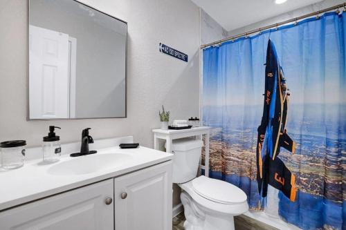 uma casa de banho com um WC, um lavatório e uma cortina de chuveiro em At Ease em San Antonio