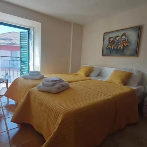 two beds in a room with yellow sheets at Casa do Cruzeiro in Castanheiro