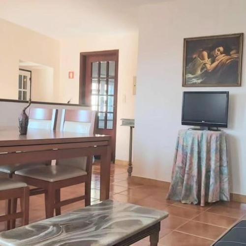 a living room with a desk and a tv at Casa do Cruzeiro in Castanheiro