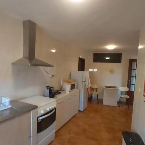 a kitchen with a stove and a refrigerator at Casa do Cruzeiro in Castanheiro