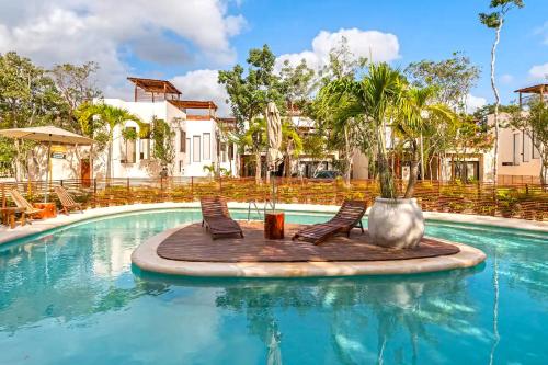 a pool with two chairs and a tree in the middle at RELAX TULUM Family Friendly Apartment in the in the jungle - pools & cenotes in Tulum