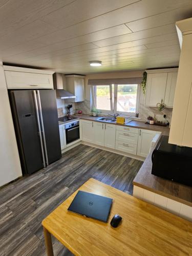 a kitchen with a table with a laptop on it at Serviced Apartment - Aberdeen in Dyce