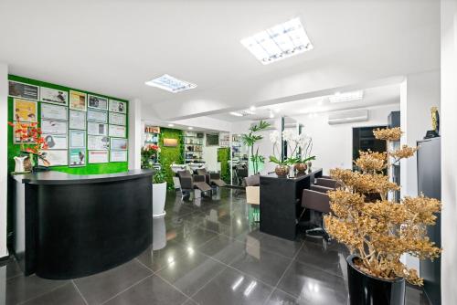 a salon with tables and chairs and plants at Capcana Hotel Jardins in Sao Paulo