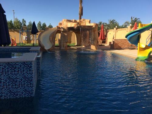 einen Pool mit zwei Rutschen in einem Wasserpark in der Unterkunft الريف الاوروبي in Madinat as-Sadis min Uktubar
