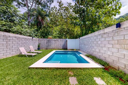 a backyard with a swimming pool in the grass at Casa Eureka in Herradura